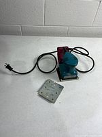 Full view of sander with cord, dust bag, detached metal plate