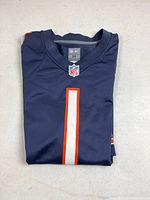 Front view of folded navy Chicago Bears Justin Fields #1 jersey showing number, NFL shield, and Nike size tag