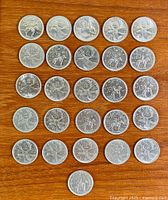 All 25 quarters arranged on wooden surface