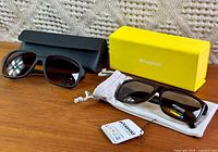 Both pairs of sunglasses with respective cases and box