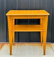 Front view showing full table, tapered legs, lower shelf