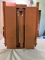 Front view of folded beechwood French box easel showing central canvas support and drawer base