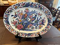 Full view of oval platter on stand showing complete bird and floral decoration