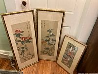 All three framed prints standing against door