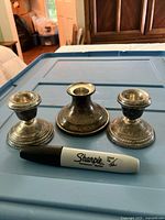 Top view showing three candlesticks next to marker for scale