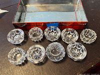 Nine clear cut glass open salt cellars displayed with box