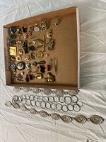 overview showing entire lot of pins in box and two belts below