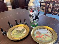 Overview of cocktail shaker, two brass plates, six boot place card holders