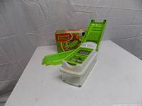 Chopper assembled with lid open, clear container attached, box in background