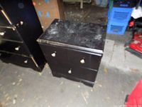Front/left perspective of nightstand showing drawers, knobs, finish wear