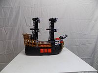 Left side profile of Fisher-Price pirate ship showing hull, cannon, masts, anchor