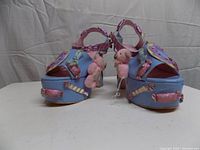 frontal view showing pair of blue platform heels with candy and teddy bear decorations