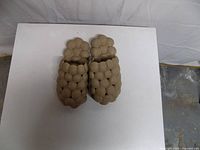 Top view of pair of tan bubble slippers on white surface