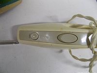 Top view of knife handle showing buttons and cord