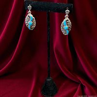 Front view of both sterling silver marcasite and turquoise earrings on stand