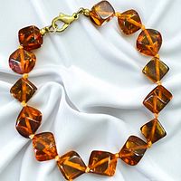 Full view of bracelet laid flat showing all amber cube beads and clasp