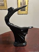 Full left profile of black Art Deco statue on table