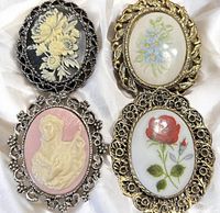 Four brooches grouped on white fabric