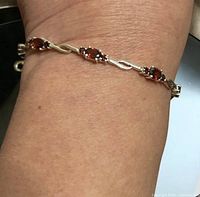 Bracelet on wrist showing garnet stones and silver links