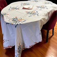 Tablecloth draped on table showing embroidery pattern and napkins