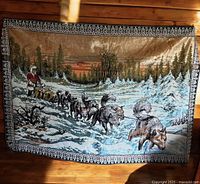 Full view of woven tapestry showing dog sled scene and decorative border
