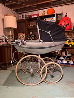 Side view of Wilson pram showing navy hood, silver body, large spoked wheels