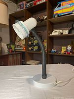 profile view of lamp showing base, neck and head