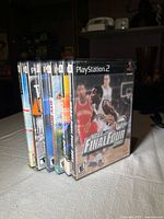 Six PS2 game cases standing, front case NCAA Final Four 2001 visible