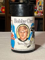 Front portrait side of Bobby Orr thermos showing name and face illustration