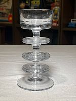 Full front view of clear glass Sheringham candlestick showing cup, three discs, stem and base