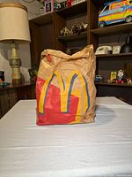 Front of crumpled supersize McDonalds bag standing on table