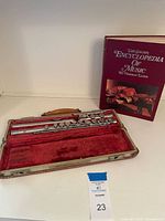 Flute in open hard case with book beside it