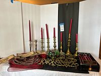 All items grouped: brass and glass candlesticks with candles, votive holders, trivet, sign, runner, boxed candles