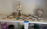 Full lot showing clock, urn and array of porcelain dishes