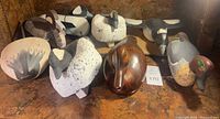 Group view of all carved duck decoys on shelf