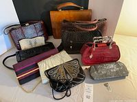 Group shot showing all eleven handbags and clutches, front and back rows
