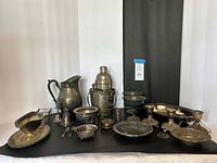 Full group shot of all tarnished silver-plated pieces against black backdrop