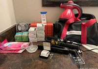 Overall lot showing steamer, bag, irons, fan, consumables, jewellery items