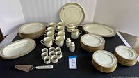 Full dinnerware set displayed including plates, cups, serving pieces