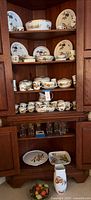 Cabinet view showing multiple Royal Worcester Evesham dinnerware pieces and glass tumblers