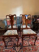 Front view of two chairs showing splat backs, cabriole legs, upholstered seats