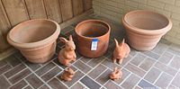 Entire lot showing three planters and four rabbit statues on tiled floor