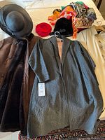 Brown suede shearling coat, black wide-brim hat, charcoal-blue jacquard coat, red hat, black velvet hat, scarves visible