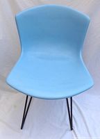 Front view of blue fiberglass shell chair on metal sled base
