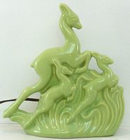 front view of green ceramic lamp showing deer design