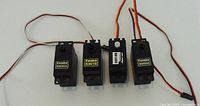 Group of four standard servos showing labels, leads and connectors