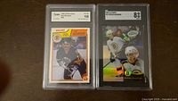 Front view of both graded cards in slabs