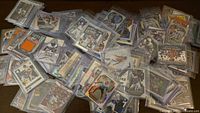 Pile of sleeved sports cards spread out on table