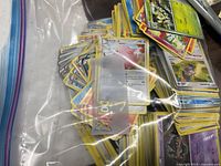 Bag of loose Pokémon cards showing mix of face-up cards including Chansey and trainer cards