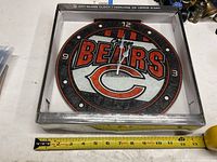 Clock in open box with tape measure showing size